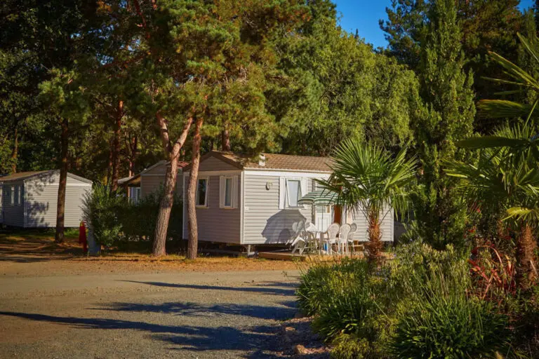 un mobil home sous les arbres