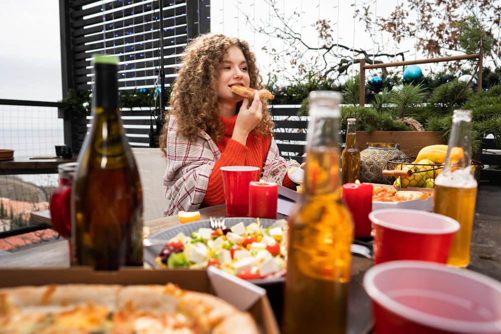 une femme mangeant sur une table extérieure de camping
