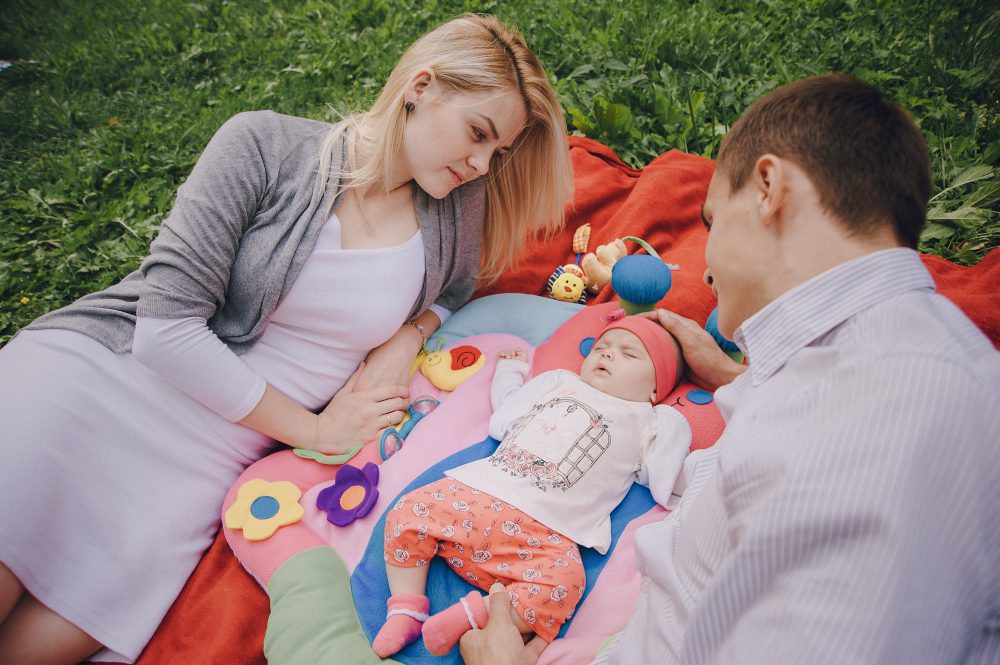 des parents regardant leur bébé faire la sieste