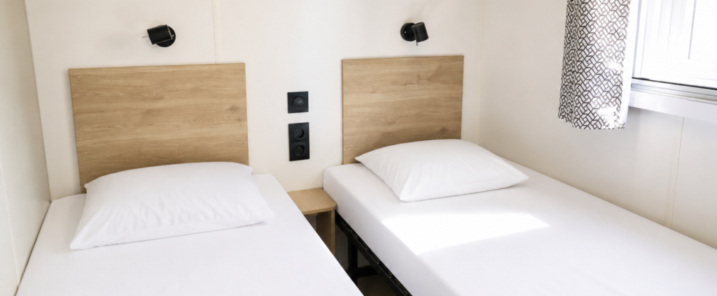 une chambre de mobil home avec deux lits séparés